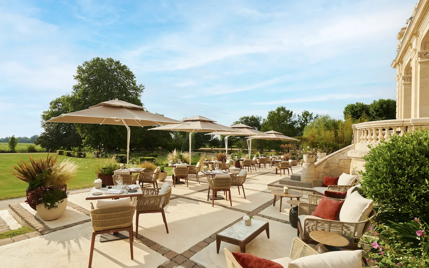Hotelterras met Talenti Cruise Teak en parasols aan een kasteel